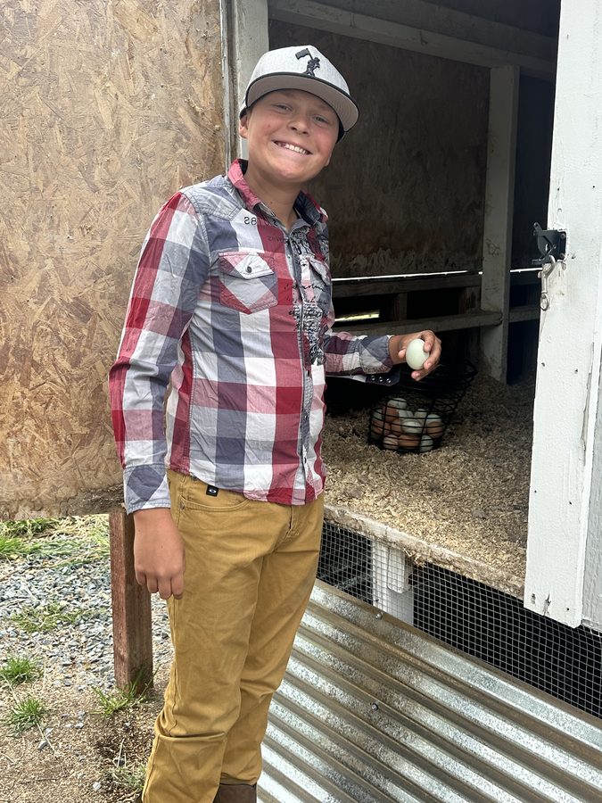 Bryce holding up one of the first eggs from his flock
