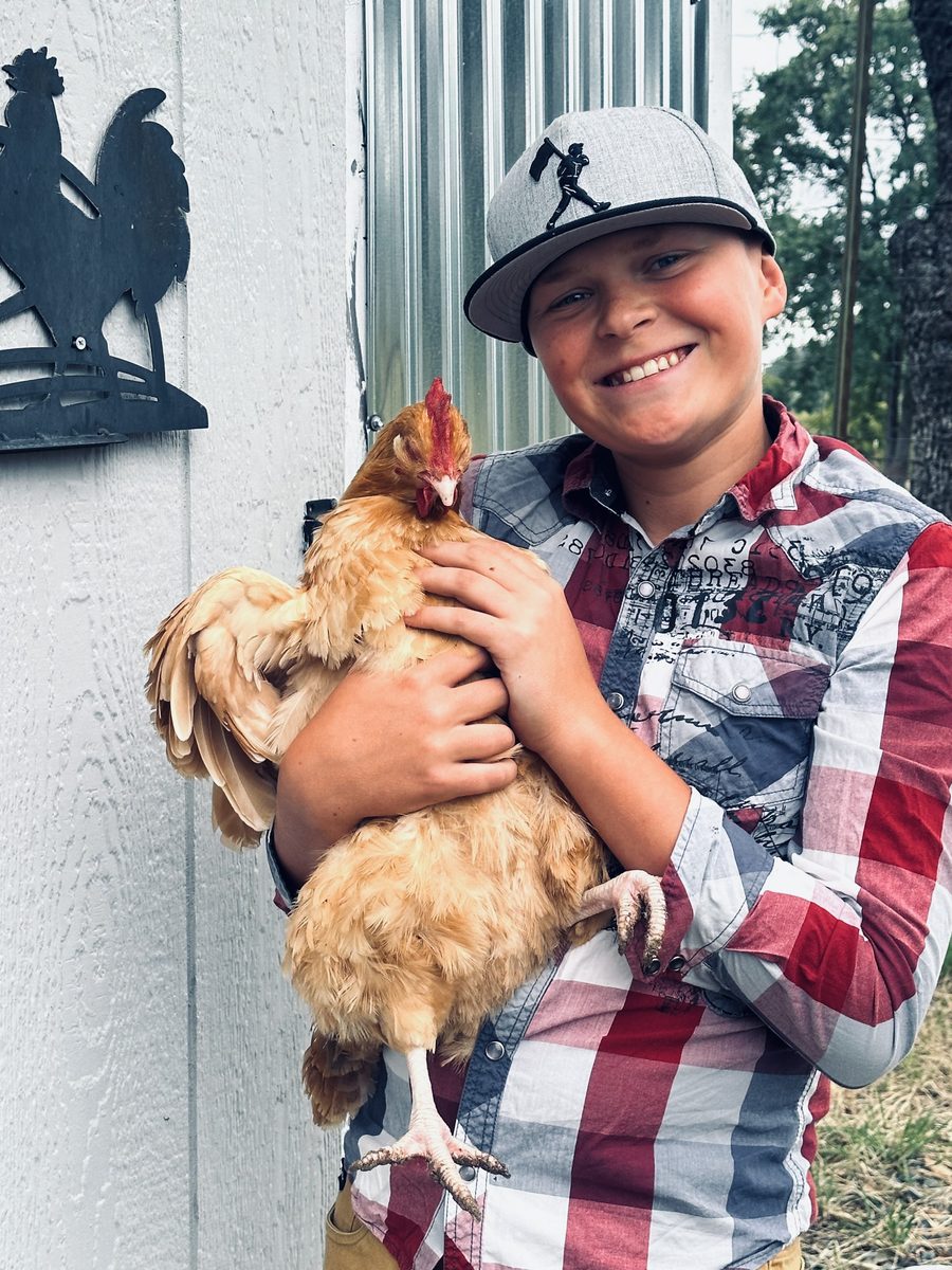 Bryce Vachel Clack holding one of his hens at the family farm in Placerville, California