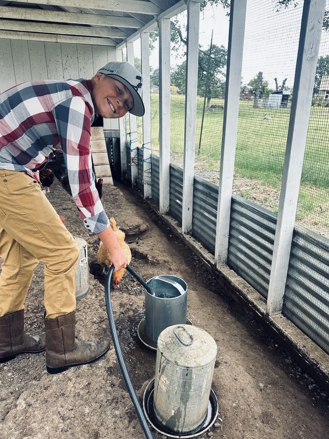 Bryce filling the chicken waterers in the coop